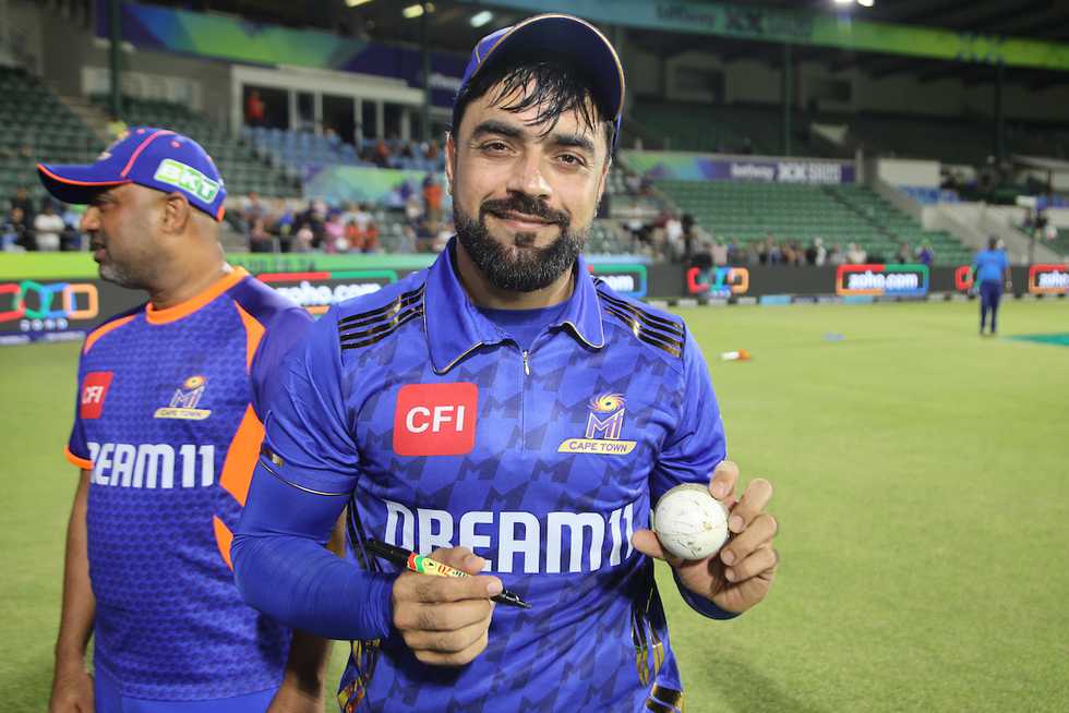 Rashid Khan signs the match ball after the game Rashid Khan signs the match ball after the game